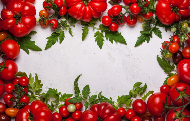 Fresh tomatoes with green leaves - Foto, afbeelding