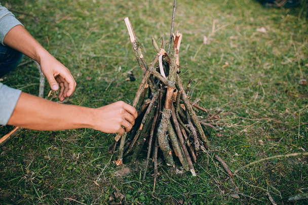 Man stacking sticks for campfire - Fotó, kép