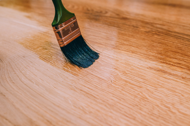 Λουστράρισμα ξύλινο πάτωμα χρησιμοποιώντας πινέλο - Φωτογραφία, εικόνα