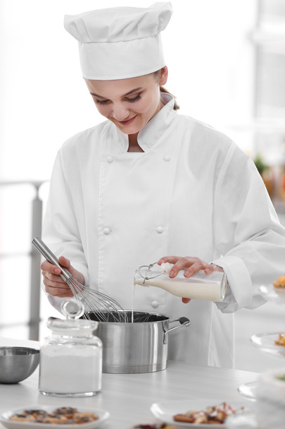Female chef working at kitchen - Foto, imagen