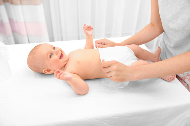 Mother changing diaper to baby  - Valokuva, kuva