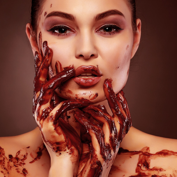 Beautiful sexual  girl with green eyes in a molten chocolate - 写真・画像