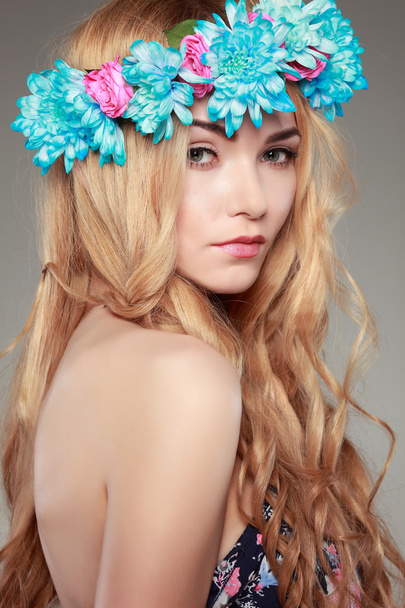 Beautiful  girl, isolated on a light - grey  background with varicoloured flowers  in hairs, emotions, cosmetics - Fotó, kép