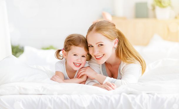 happy family mother and child playing and laughing in bed  - Foto, Imagem