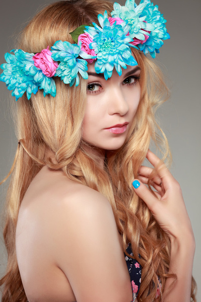 Beautiful  girl, isolated on a light - grey  background with varicoloured flowers  in hairs, emotions, cosmetics - Fotó, kép