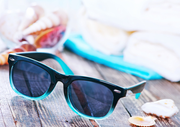 sunglasses and shells on  backgroubd - Foto, afbeelding