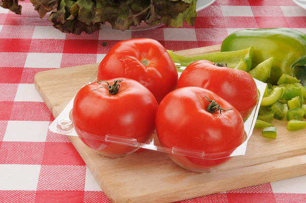 Container of fresh tomatoes with green peppers - Photo, image