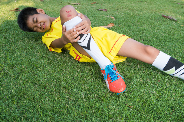 Γκρο πλαν αρσενικό ποδοσφαιριστή που πάσχουν από τραυματισμό στο γόνατο για να - Φωτογραφία, εικόνα