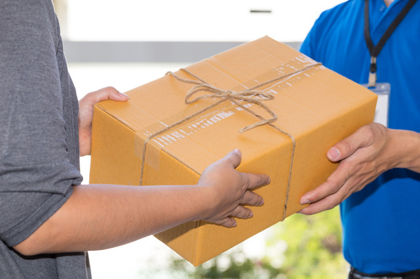 Mulher mão aceitar uma entrega de caixas de entregador
 - Foto, Imagem