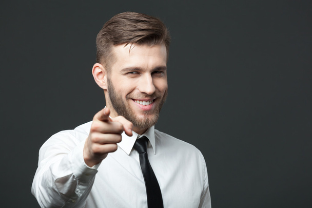 Young handsome businessman pointing at you  isolated on gray bac - Фото, зображення
