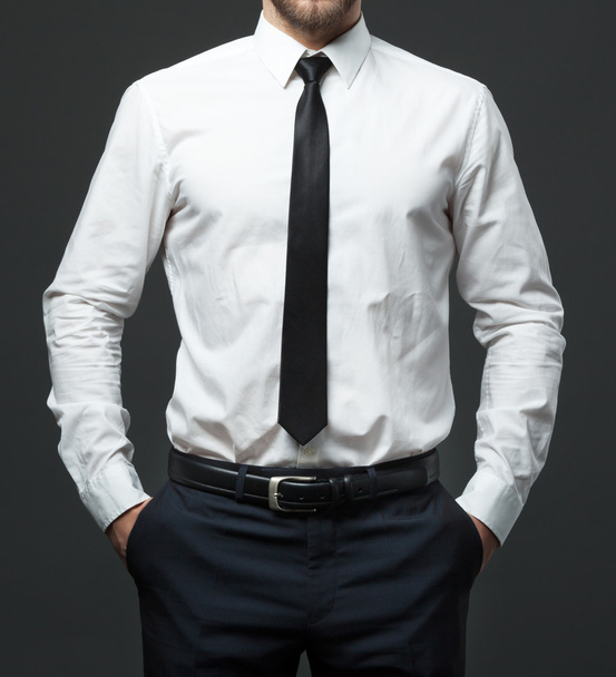 Midsection of young businessman in formal white shirt, black tie - Foto, Bild
