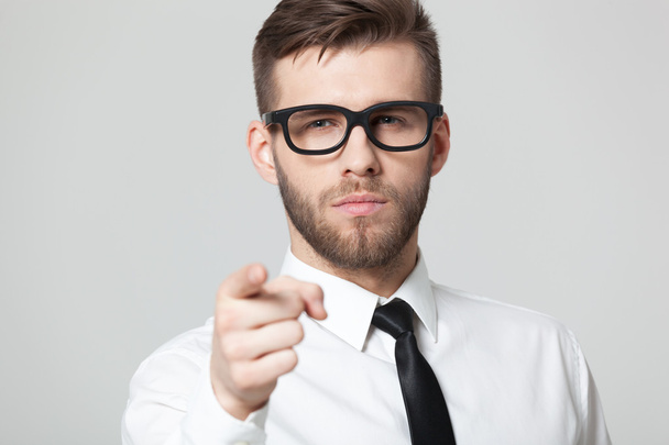 Young handsome businessman pointing at you  isolated on gray bac - Photo, Image