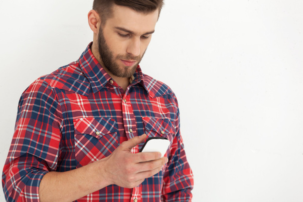 Handsome young man in casual wear typing text message. - Fotoğraf, Görsel