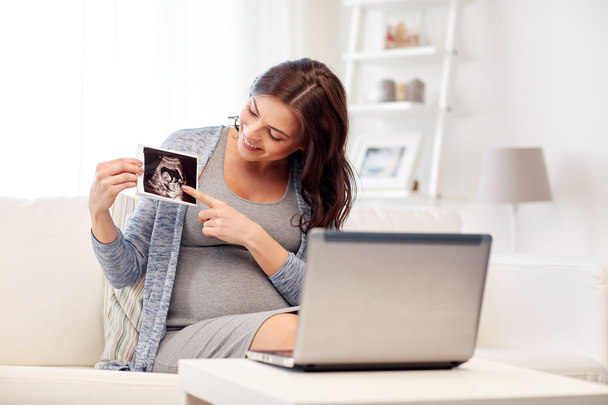 happy pregnant woman with ultrasound image at home - Zdjęcie, obraz