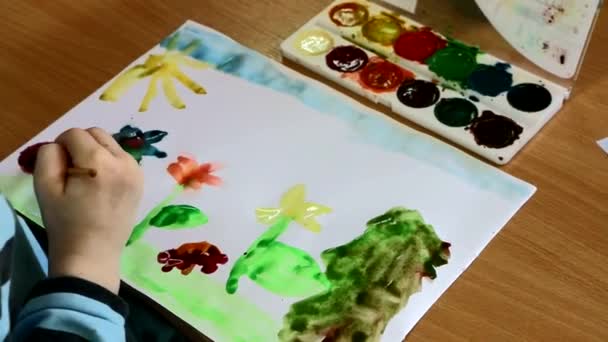子どもの創造性。子供は、水彩画を描画します。彼は空想に没頭しています。それは熱意と喜びを作成し、発明 - 映像、動画