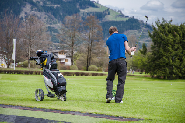 Golfaaja lyö palloa
 - Valokuva, kuva
