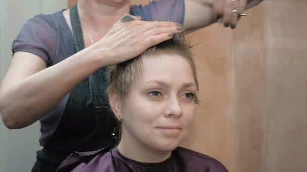 Friseur schneidet Kämme und frisiert Damenhaare - Filmmaterial, Video