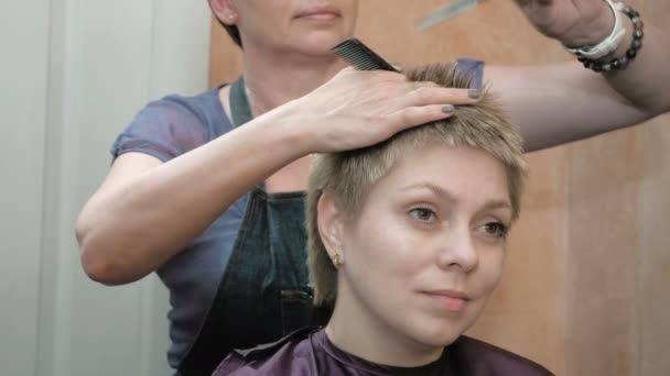 Friseur schneidet Kämme und frisiert Damenhaare - Filmmaterial, Video