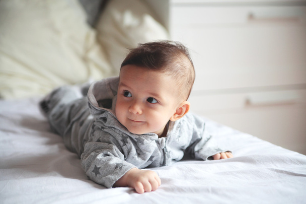 Laughing baby.Small baby crawling on the bed in white room.On hi - Фото, зображення