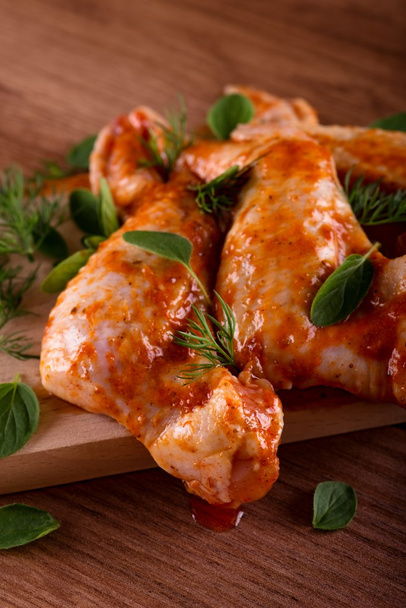 Several marinated chicken wings with green herbs - Photo, Image
