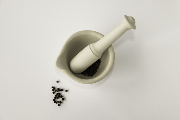 Lay flat image of mortar and pestle with black peppercorns - Valokuva, kuva