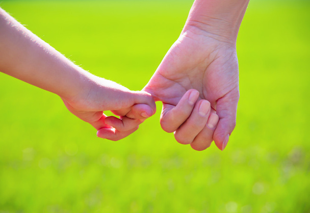 родитель держит за руку маленького ребенка - Фото, изображение