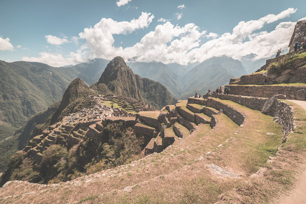 Machu Picchu archeological site, wide angle view from the terraces above with scenic sky. Toned image. - Photo, image