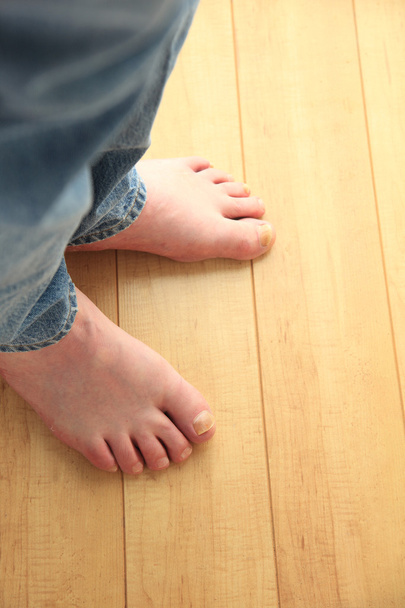 Barefoot man op vloer - Foto, afbeelding