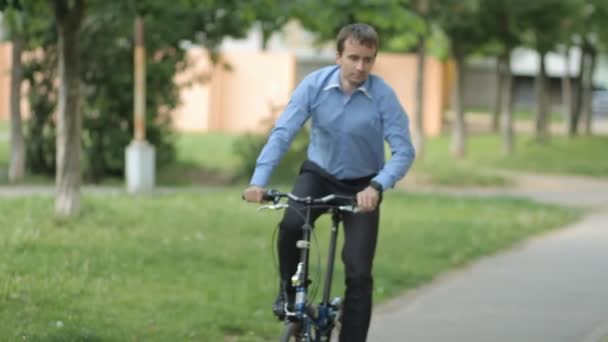 Biznesmen z mały rower do ławki - Materiał filmowy, wideo