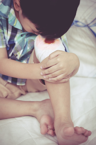 Nahaufnahme. Kind verletzt. Wunde am Knie des Kindes mit Verband. - Foto, Bild