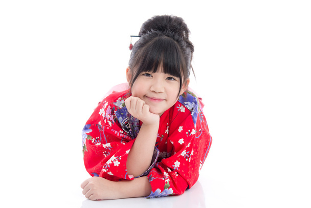 Belle fille asiatique en kimono rouge couché sur fond blanc isolé
 - Photo, image