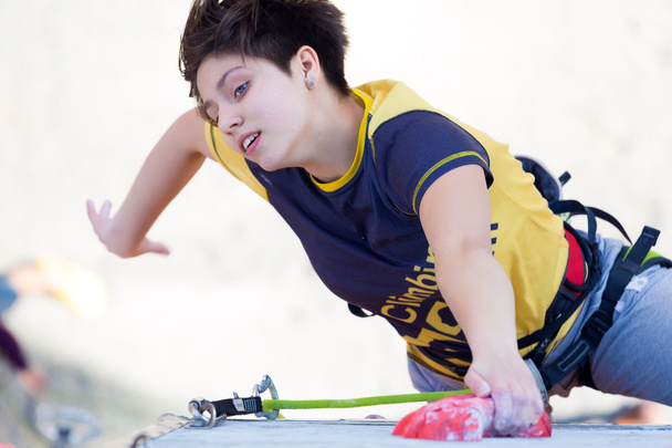 Junior female Athlete makes hard move on climbing Wall - Fotó, kép