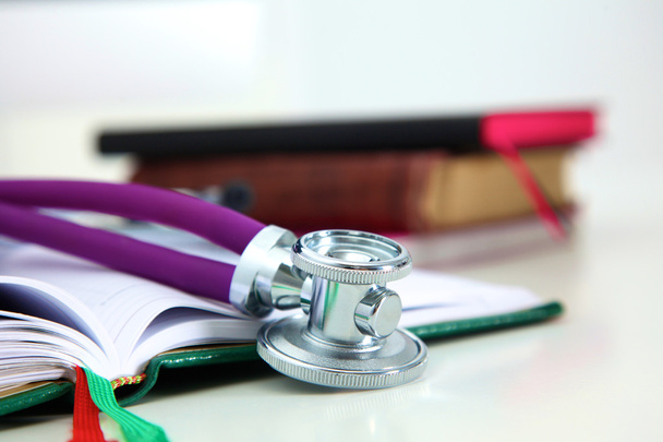 Stethoscope lying on a table on an open book - Photo, Image