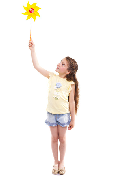 Happy girl playing with a toy windmill - Zdjęcie, obraz