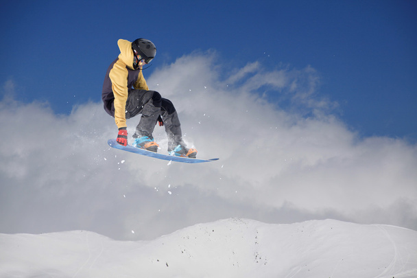Jeździec na snowboardzie skaczący po górach. Ekstremalne snowboard freeride sportu. - Zdjęcie, obraz