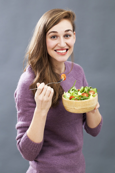 uśmiechnięta 20s dziewczyna gotowa do jedzenia apetyczny warzywko dla przyjemności posiadania świeżej diety - Zdjęcie, obraz