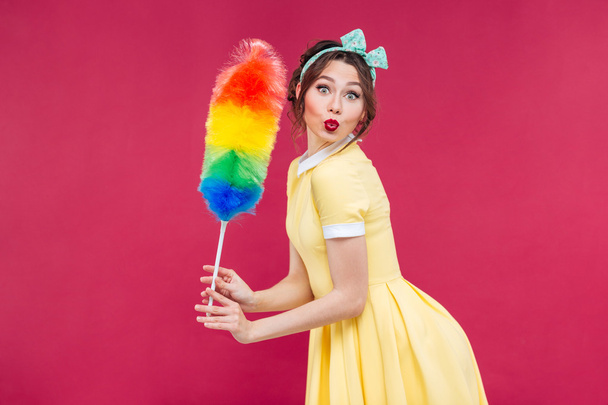 Charming playful pinup girl with colorful cleaning broom - Foto, Bild