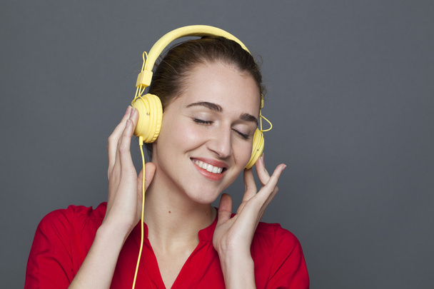 cheerful young woman enjoying music on her headphones - Valokuva, kuva