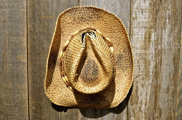 Stary słomkowe kapelusze wisi na wyblakły drewna ściany - Zdjęcie, obraz