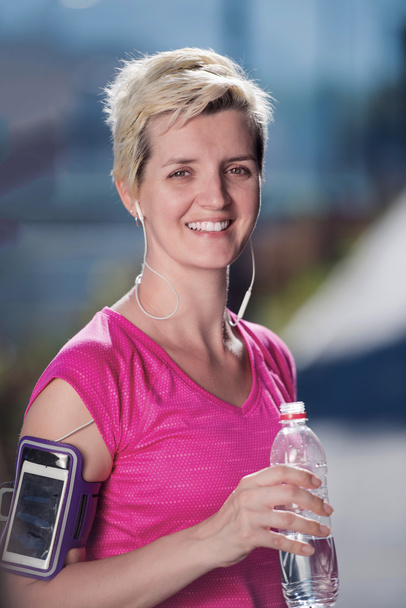 vrouw drinken water na joggen - Foto, afbeelding