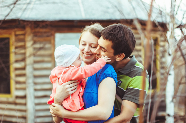 Μητέρα, πατέρας και μωρό κόρη αγκάλιασμα και χαμογελαστός. - Φωτογραφία, εικόνα