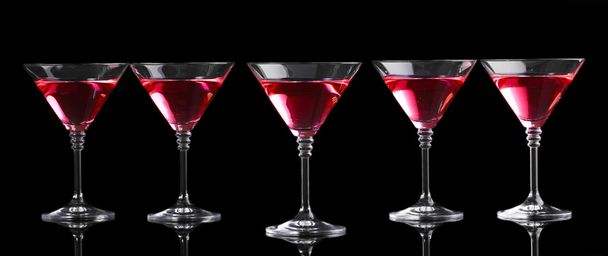 Red cocktail in martini glasses isolated on black - Zdjęcie, obraz