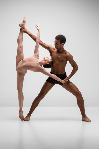 Couple of ballet dancers posing over gray background - Foto, Imagem
