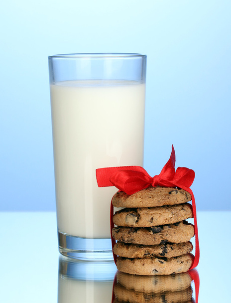 Glass of milk and cookies on blue background - 写真・画像