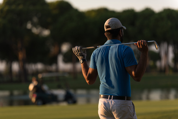 golfista de vuelta en el curso mirando al agujero en la distancia
 - Foto, imagen