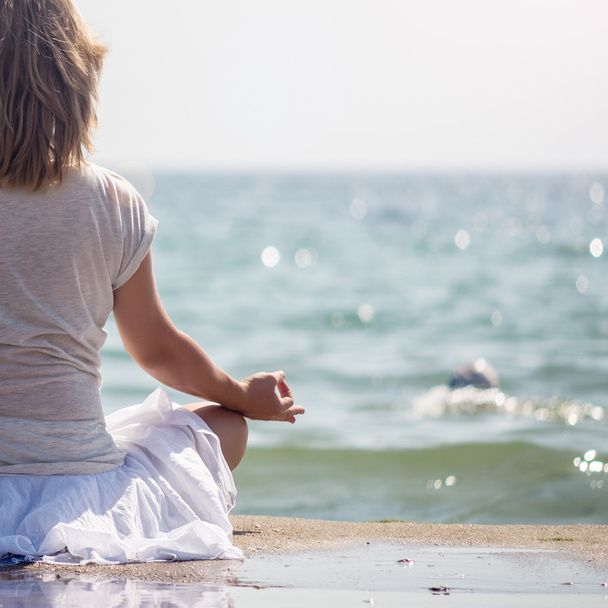 Woman meditating at the sea - Foto, afbeelding
