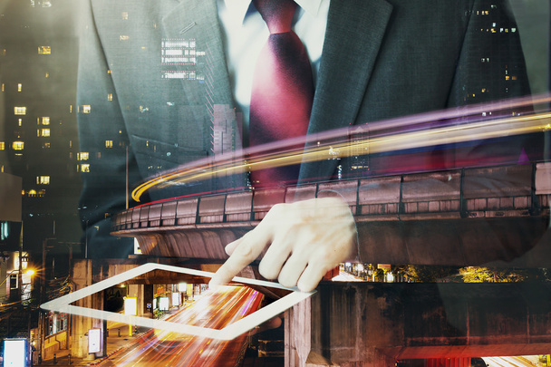 Double Exposure of Businessman touching a tablet in long exposure city scene. - Фото, изображение