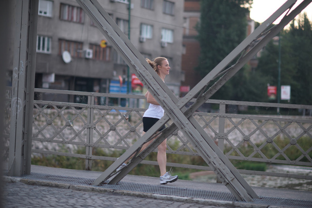 sporty woman running  on sidewalk - Фото, зображення