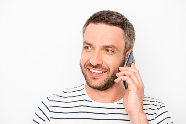 Cheerful man with beaming smile having conversation on phone - Φωτογραφία, εικόνα