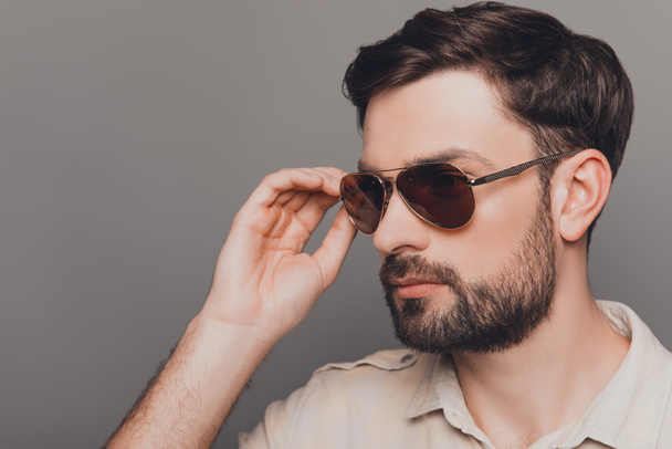 Portrait of handsome brutal bearded man touching his spectacles - Foto, Imagem
